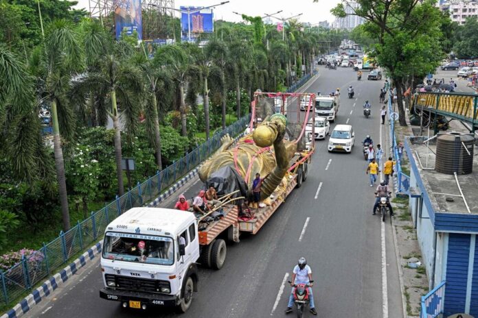 Workers use a hydraulic crane to remove Lionel Messi’s 70-foot statue in Kolkata after safety concerns emerged.