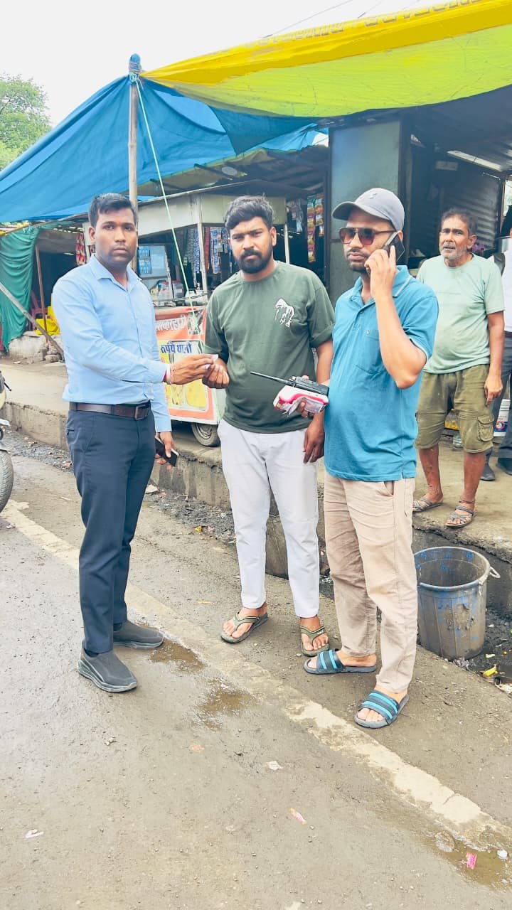 BMC official handing over a spot fine receipt to a shopkeeper in Bhopal.