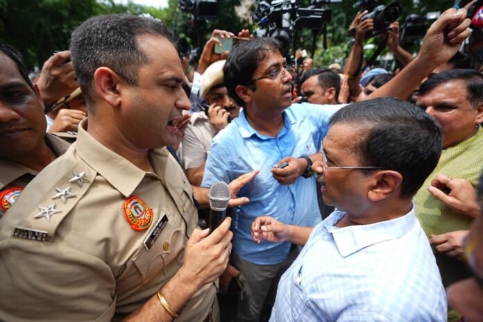 Kejriwal and supporters sat on Firoz Shah Road after police stopped their E20 petrol march.